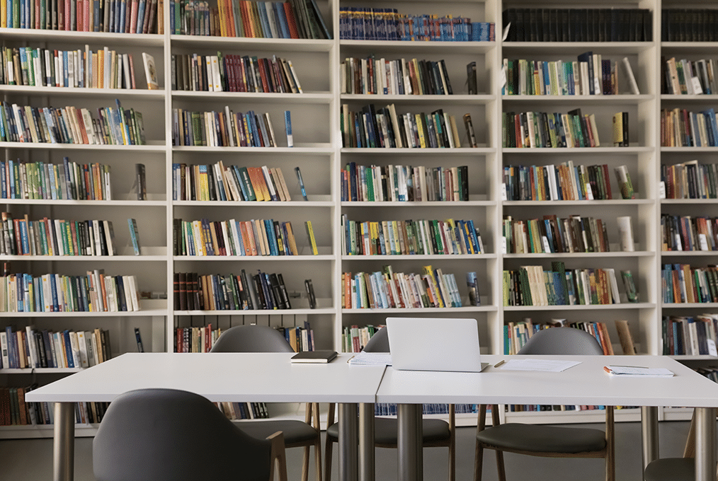 interior of a university library. a table sits in front of some bookshelves